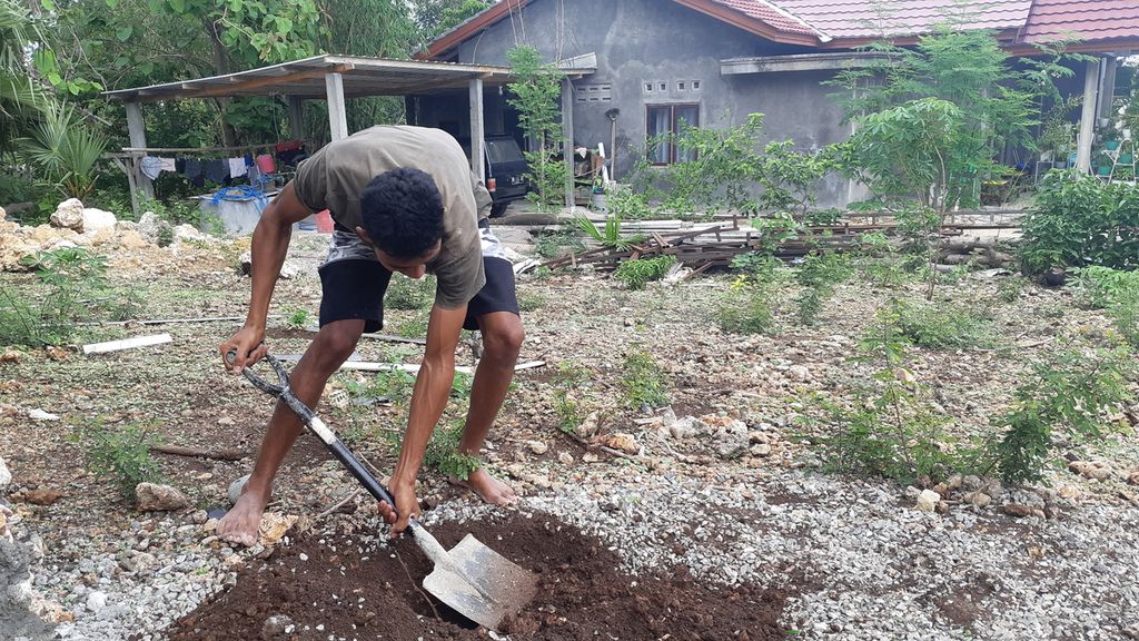 Roni (25), warga Kelurahan Bello, Kota Kupang, Nusa Tenggara Timur, menggali lubang untuk menyerap air pada Senin (22/11/2021). Hal tersebut dilakukan untuk menambah air tanah agar sumur terdekat tidak kering pada saat kemarau panjang.