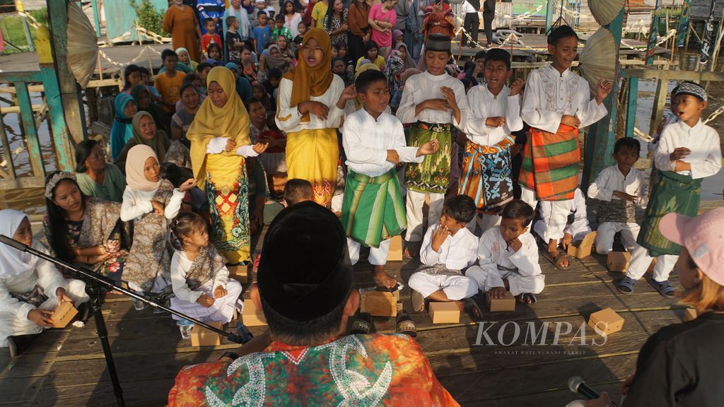 Anak-anak menari dan bernyanyi diiringi seniman madihin, Ahmad Syarani, di Dermaga Pasar Terapung Muara Kuin, Banjarmasin, Kalimantan Selatan, Sabtu (9/9/2023). 