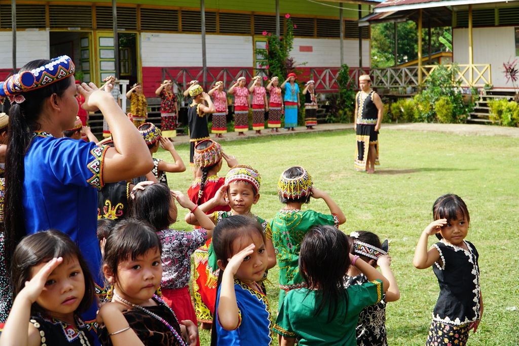 Siswa SDN 03 Long Tuyoq melaksanakan upacara bendera dengan memakai pakaian adat di Desa Long Tuyoq, Kecamatan Long Pahangai, Mahakam Ulu, Kalimantan Timur, Kamis (2/5/2019).