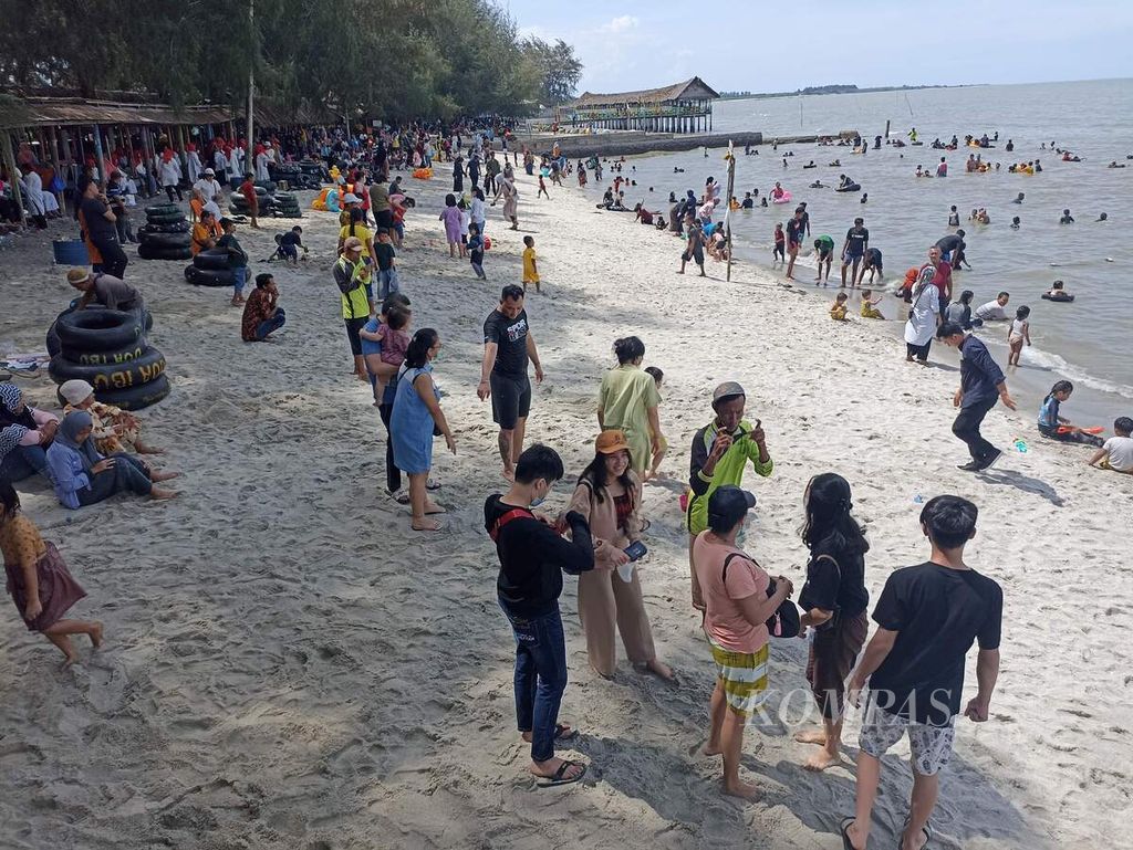 Wisatawan memadati kawasan wisata Pantai Cermin, di Kabupaten Serdang Bedagai, Sumatera Utara, Minggu (6/2/2022). Tempat-tempat publik di Sumut semakin ramai di tengah peningkatan pesat kasus Covid-19.