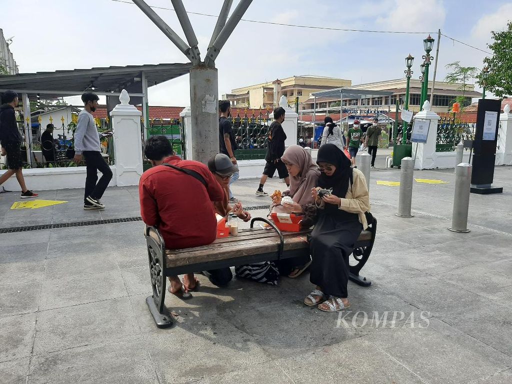 Satu keluarga asal Malang, Jawa Timur, duduk dan menikmati makanan di bangku trotoar Malioboro, Yogyakarta, Kamis (5/5/2022).