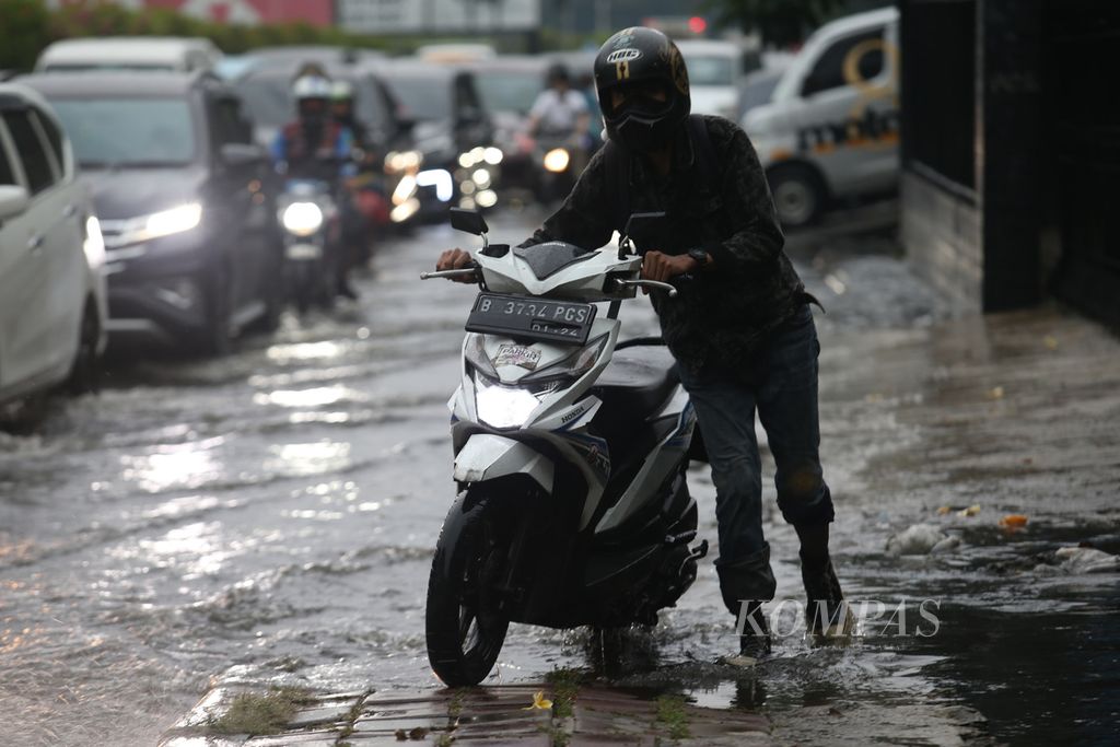Pengendara menembus genangan air saat hujan deras mengguyur kawasan Gandaria, Jakarta, Jumat (22/4/2022). 