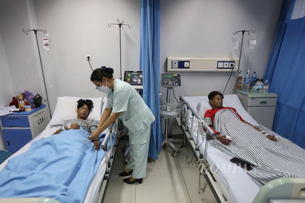 A nurse checks the condition of a patient with dengue hemorrhagic fever who is being treated at Taman Sari Regional Hospital, Jakarta, Tuesday (16/4/2024).
