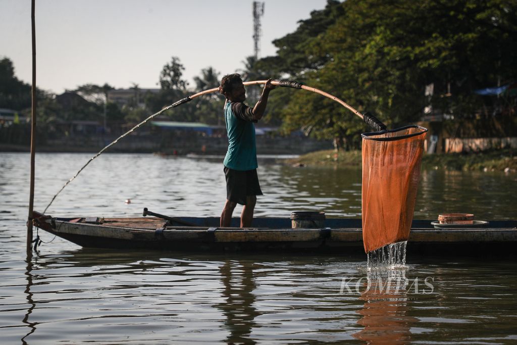 Pencari cacing sutra mengangkat jaring di Sungai Cisadane, Kalipasir, Kota Tangerang, Banten, Jumat (9/6/2023). 