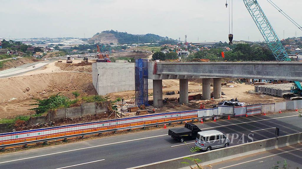 Sejumlah kendaraan yang keluar dari Jalan Tol Semarang melintas di bawah pembangunan Simpang Susun Krapyak, yang merupakan bagian dari proyek jalan tol Batang-Semarang, di Kota Semarang, Jawa Tengah, 16 Mei 2018. 