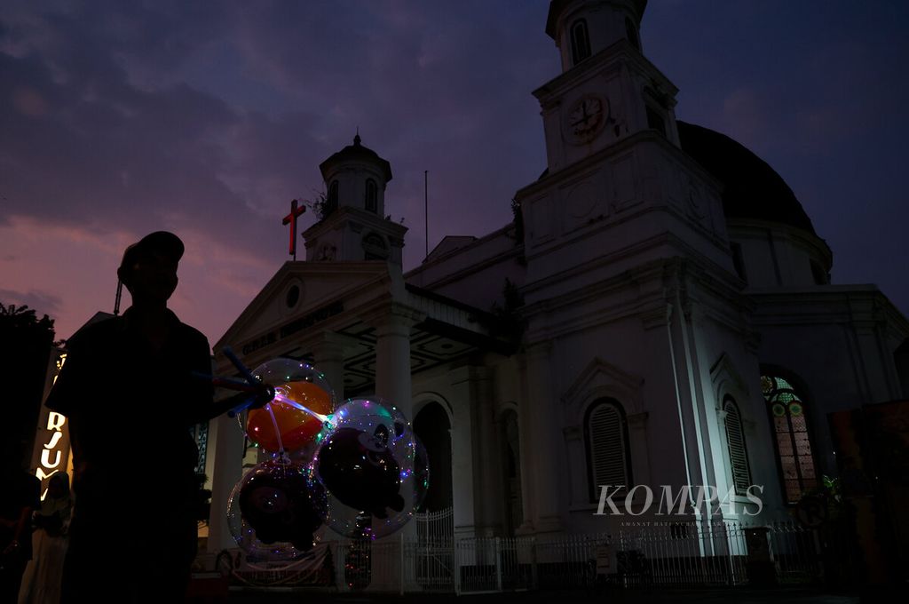 A balloon seller passes by in the background of Immanuel GPIB Church Semarang, also known as Blenduk Church, located in the Old City of Semarang, Central Java, on Saturday (23/12/2023).