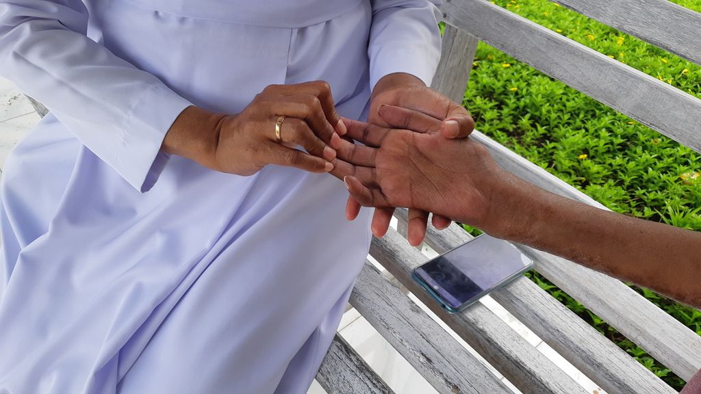 Suster Alexia memerik tangan pasien kusta di Rumah Sakit Kusta Pembantu Abadi, Desa Naob, Kabupaten Timor Tengah Utara, Nusa Tenggara Timur pada Oktober 2022.
