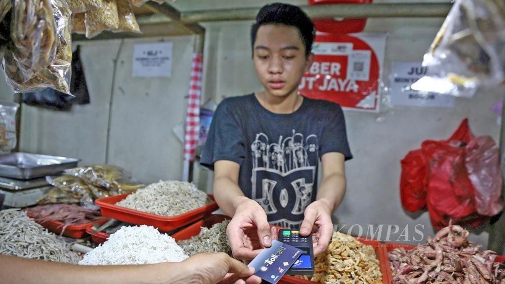 Pedagang ikan asin menerima pembayaran dengan menggunakan <i>e-money</i> di Pasar Mayestik, Jakarta Selatan, Kamis (18/10/2018). 