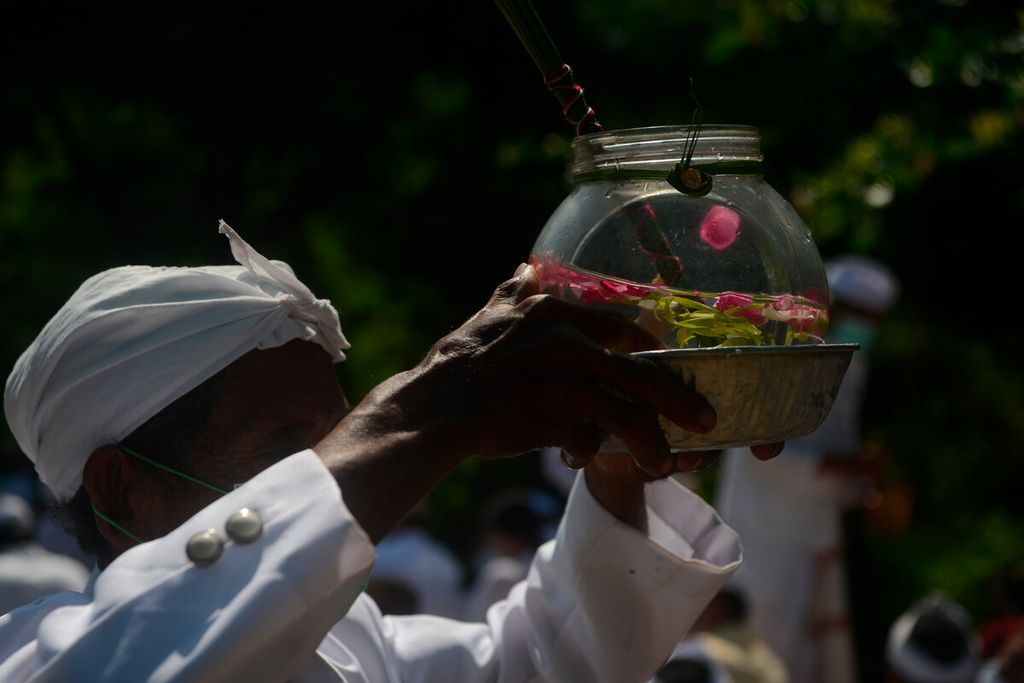 One of the pedandas brings holy water to be sprinkled for Hindus who attend the Melasti prayer and ceremony at the Beach, Marina, Semarang City, Central Java, Sunday (27/2/2022). This holy water is a symbol to wash and cleanse oneself from sins ahead of the Nyepi celebration.