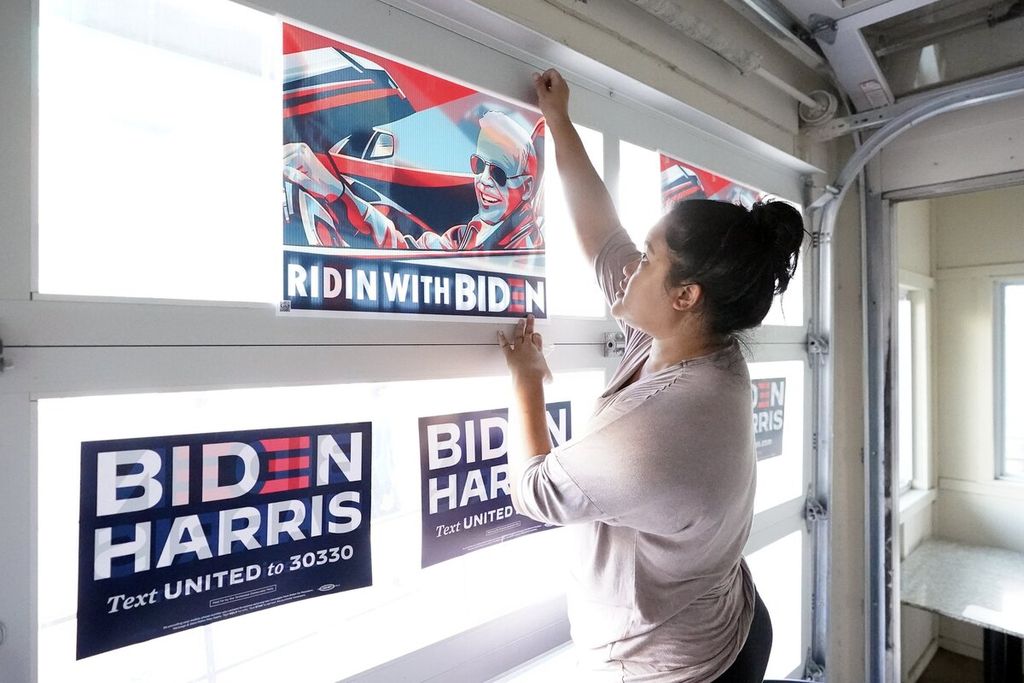 Pemilik restoran Anna Myint memasang tanda kampanye Joe Biden pada jendela restorannya yang berada di dekat lokasi debat calon presiden Amerika Serikat di Belmont University, Nashville, Tennessee, AS, 22  Oktober 2020. 