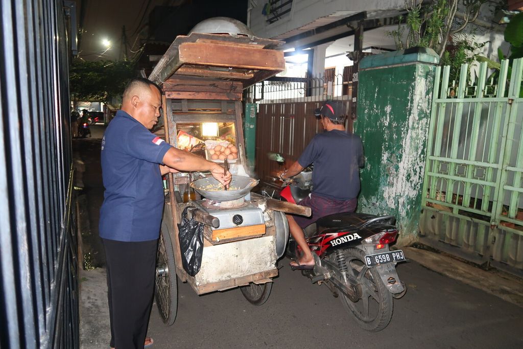 Penjual nasi goreng tek-tek keliling, Kober, memasak di salah satu wilayah perumahan di Kemanggisan, Jakarta Barat, Jumat (14/10/2022) 