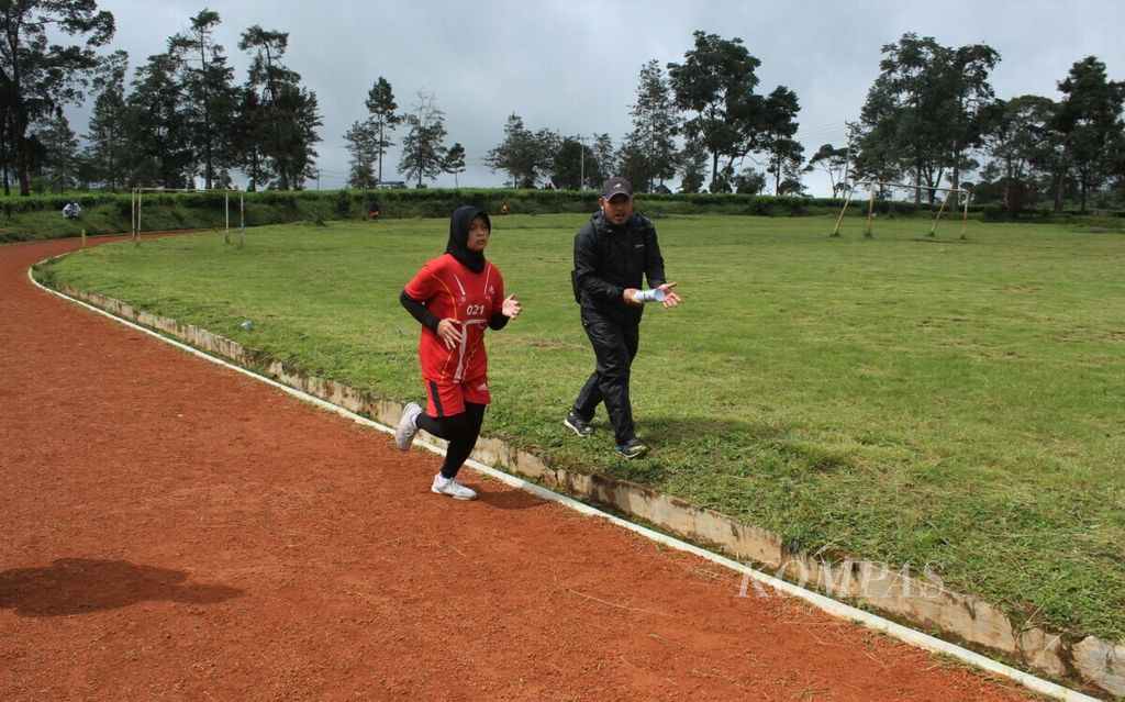 Guru olahraga SMK Negeri 5 Pangalengan Taufik Saleh (kanan) menyemangati siswanya yang mengikuti Pangalengan Track Race 2020 di Lapangan Babakan Tanara, Pangalengan, Kabupaten Bandung, Jawa Barat, Sabtu (19/12/2020). Lomba yang diadakan Agung Mulyawan Track Club (AMTC) itu melibatkan guru-guru olahraga setempat untuk memantau bakat pelari lokal. 