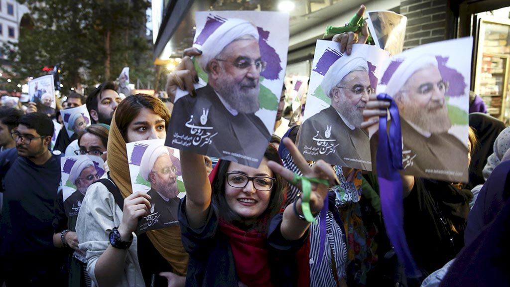 Pendukung  calon presiden petahana Hassan Rouhani mengangkat poster bergambar wajah Rouhani dalam perayaan kemenangan Rouhani pada pemilu presiden Iran di Teheran, Iran, Sabtu (20/5). Puluhan ribu pendukung merayakan kemenangan itu dengan turun ke jalan. Dengan kemenangan itu, Rouhani akan menjabat sebagai presiden Iran untuk kedua kalinya. 