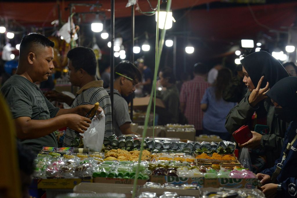 Pedagang memasukkan kue yang dipesan pembeli di Pasar Kue Subuh Senen Blok 5, Jakarta Pusat, Selasa (17/1/2023). 