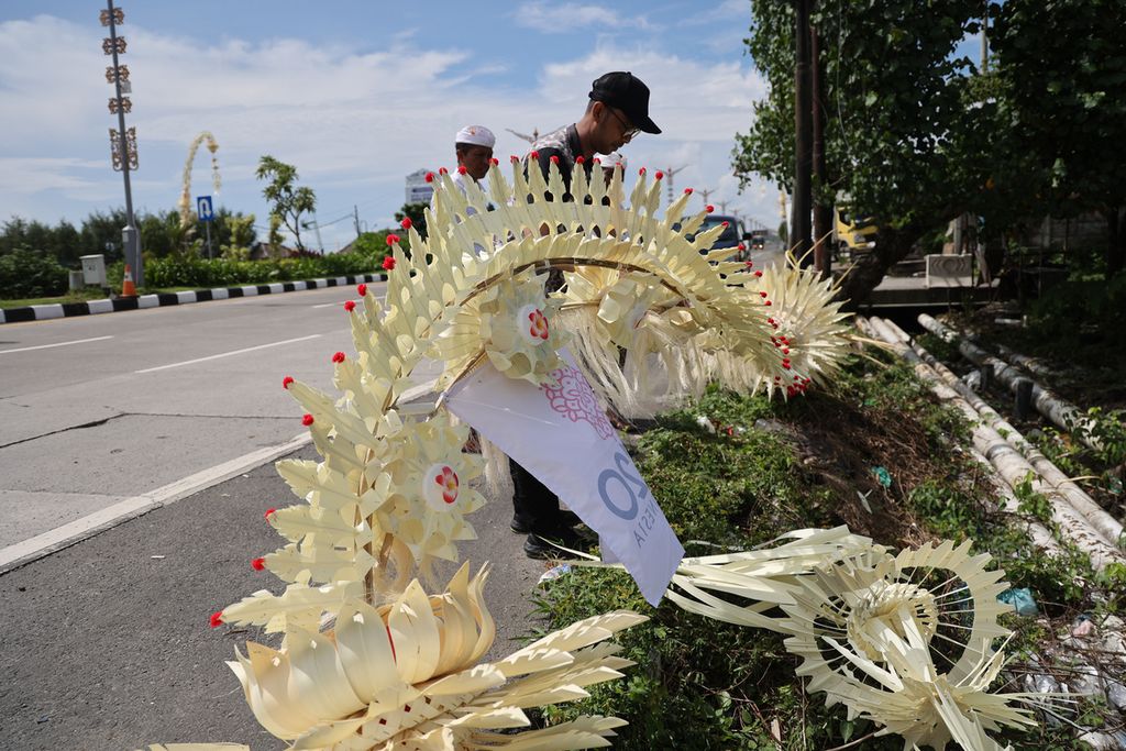 Two residents prepare a penjor to be installed on the edge of Jalan I Gusti Ngurah Rai, Badung, Bali, Tuesday (8/11/2022). A total of 21 traditional villages in Bali established penjors to welcome guests from countries participating in the G20 Summit.