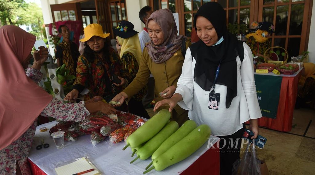 Pengunjung membeli hasil pertanian yang dijual di salah satu stan peserta Festival Urban Farming Surabaya 2023 di Balai Pemuda, Surabaya, Jatim, Selasa (30/5/2023). Festival yang diselenggrakan dari 30 Mei hingga 4 Juni 2023 menghadirkan beragam jenis produk <i>urban farming</i> hingga pelatihan atau <i>workshop</i> budidaya pertanian. Festival Urban Farming ini diikuti 135 kelompok tani yang tersebar di 31 kecamatan Surabaya. 