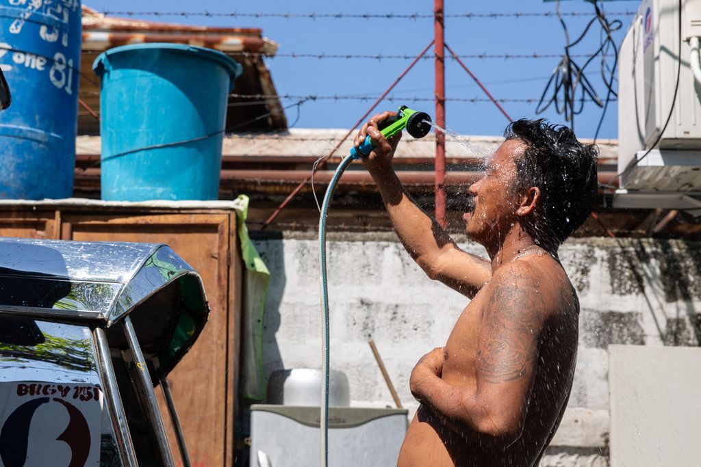 Seorang pria menyiram badannya dengan air saat cuaca panas ekstrem di Manila, Filipina, Minggu (28/4/2024) 