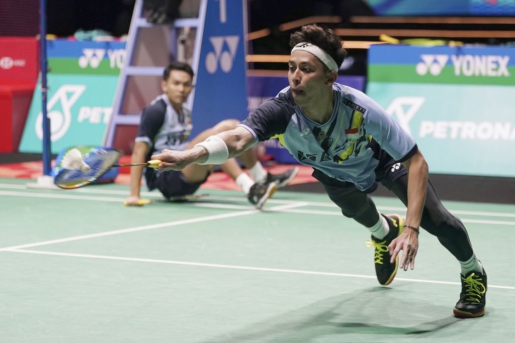 Indonesian men's doubles player, Muhammad Rian Ardianto (front), tries to reach the shuttlecock against Chinese doubles, Liang Wei Keng and Wang Chang, in the 2023 Malaysia Open final at the Axiata Arena, Kuala Lumpur, Malaysia, Sunday (15/1/2023) . Fajar/Rian won 21-18, 18-21, 21-13..
