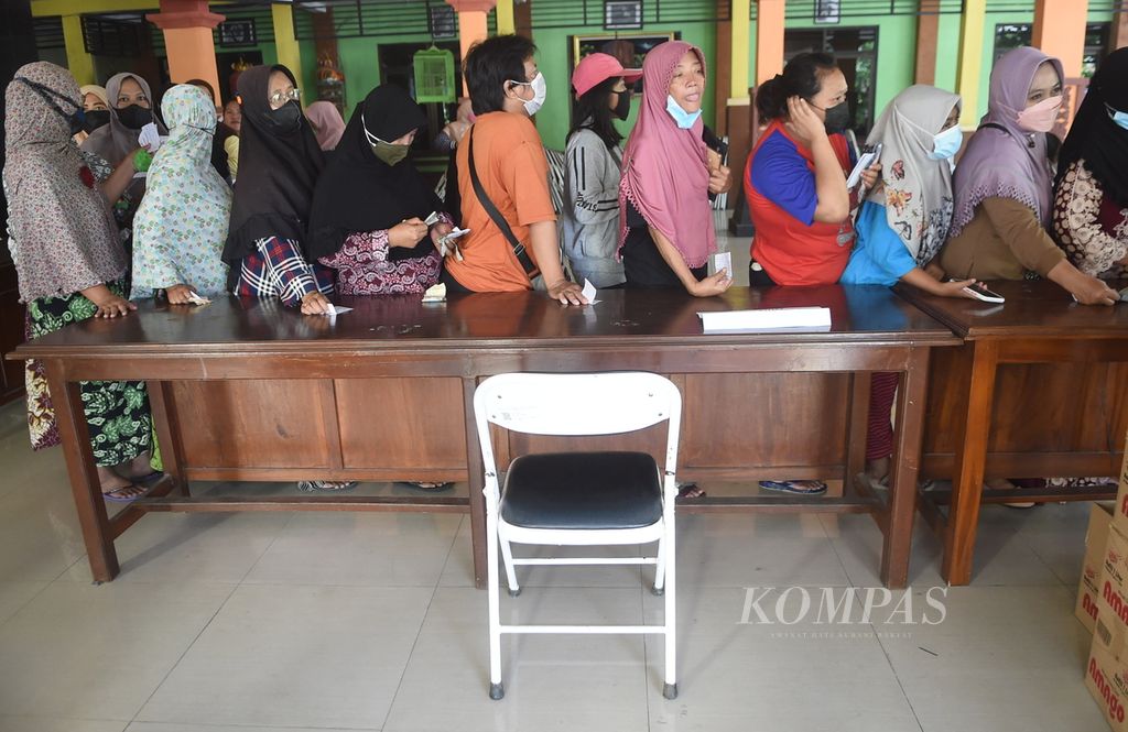 Warga antre saat Operasi Pasar Minyak Goreng di Kantor Kecamatan Waru, Kabupaten Sidoarjo, Jawa Timur, Senin (24/1/2022).  