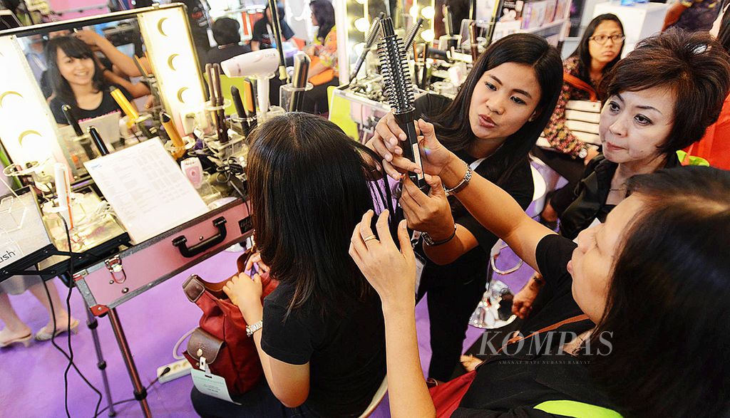 Pengunjung mencoba perawatan rambut di sebuah pameran industri kecantikan.