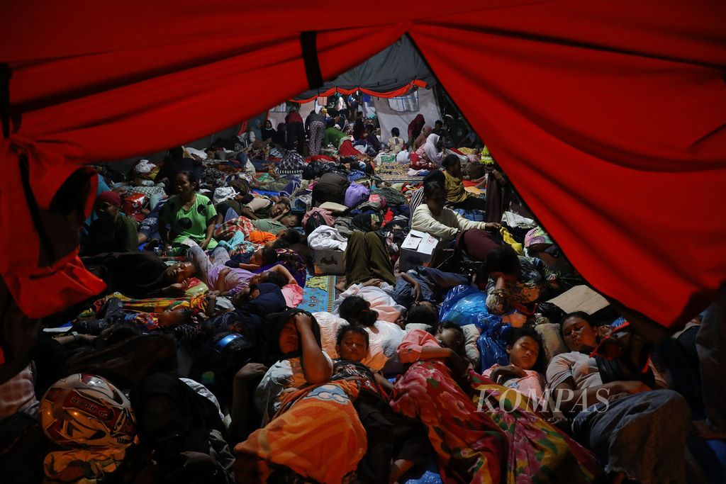 Pengungsi beristirahat di tenda yang didirikan di halaman Kantor Bupati Pasaman Barat, Pasaman Barat, Sabtu (26/2/2022) malam. Mereka merupakan warga korban gempa bermagnitudo 6,1 dari sejumlah tempat di Pasaman Barat.