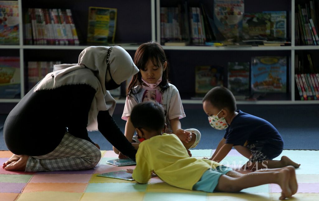 Orangtua mendampingi anak-anak membaca buku di Perpustakaan Umum dan Depo Arsip di Rawa Bunga, Jatinegara, Jakarta Timur, Selasa (28/12/2021). Sebagian anak-anak memilih untuk memanfaatkan waktu libur sekolah dengan mengunjungi perpustakaan umum. Selain membaca koleksi buku yang tersedia, mereka juga dapat menonton film-film edukatif yang diputar setiap hari. Perpustakaan ini menyediakan 17.000 koleksi buku kategori anak-anak. 