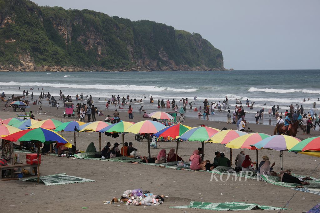 Pelancong mengunjungi Pantai Parangtritis, Bantul, DI Yogyakarta, Minggu (14/4/2024), saat libur Lebaran.