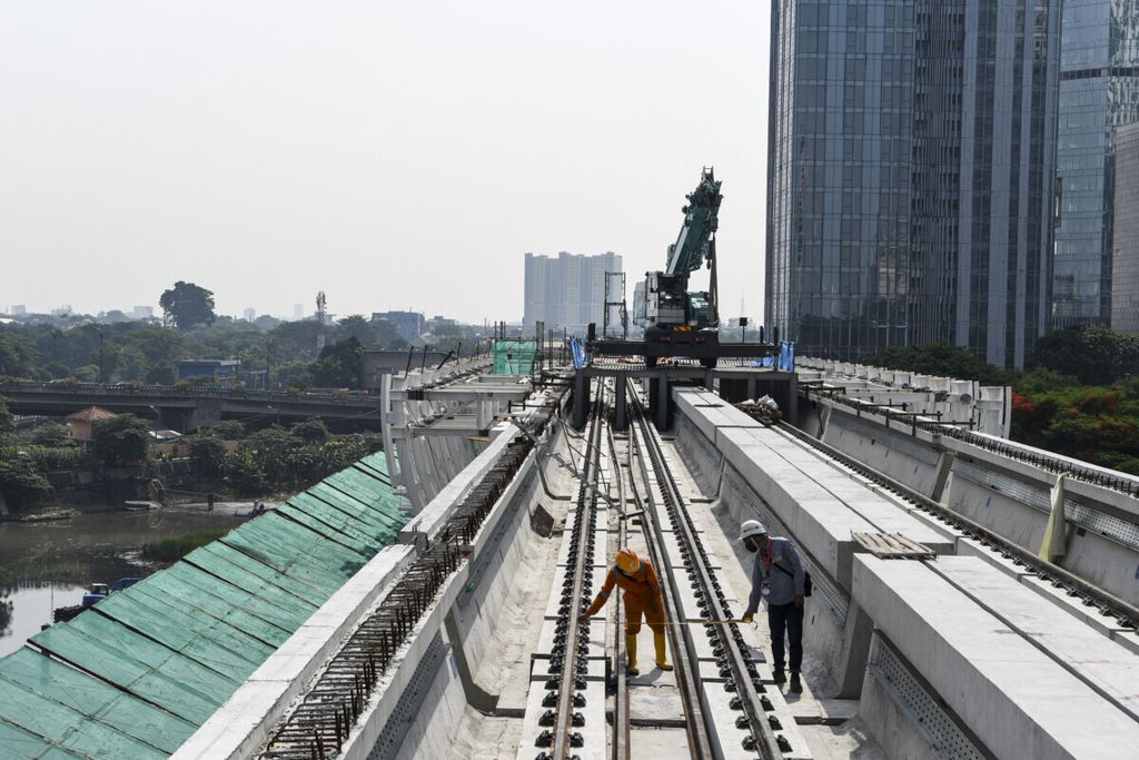 Dua pekerja menyelesaikan proyek pembangunan <i>longspan</i> atau jembatan bentang panjang lintasan <i>light rail transit</i> (LRT)’ di kawasan Dukuh Atas, Jakarta, Rabu (11/11/2020). PT Adhi Karya (Persero) Tbk telah menyelesaikan pembangunan <i>longspan</i> terakhir sepanjang 218 meter yang menghubungkan lintasan LRT dari Cawang-Kuningan-Dukuh Atas. 