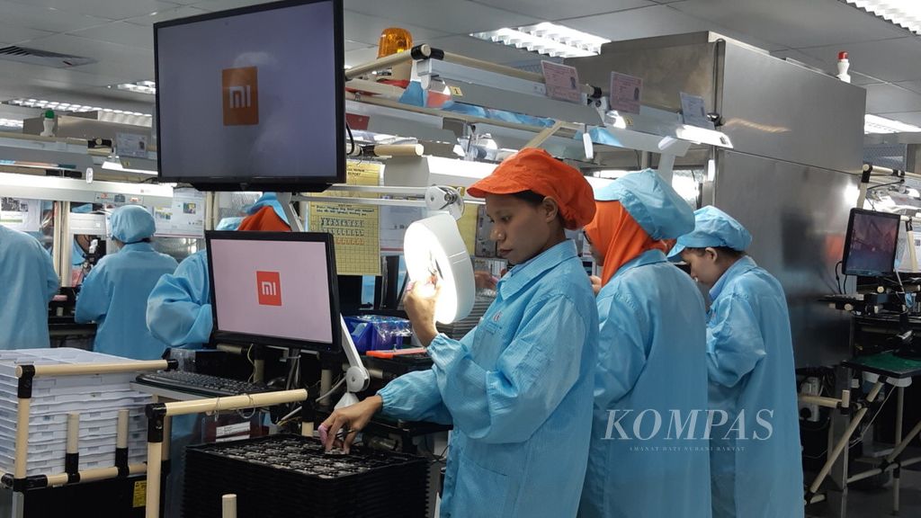 An assembler checks the integrity of one of the main components of the Redmi Note 7 mobile phone at the assembly factory of PT Aat Nusapersada, Batam, on Monday (20/5/2019). This work is the first stage in the assembly of the latest Xiaomi mobile phone.