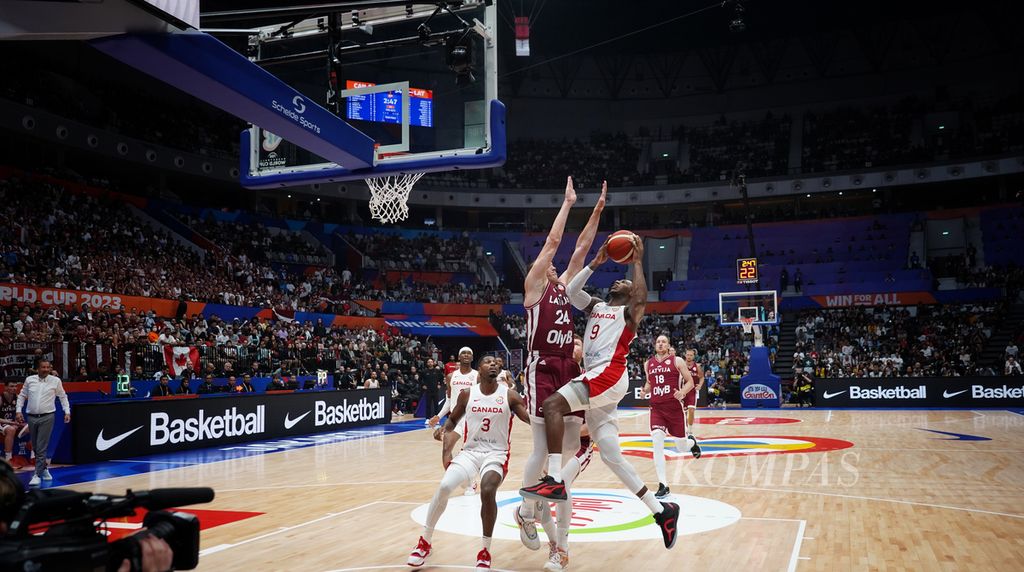 Pemain tim Kanada, RJ Barrett (kanan), dihadang pemain tim Latvia, Andrejs Grazulis, dalam laga penyisihan Grup H Piala Dunia FIBA 2023 di Stadion Indonesia Arena, Jakarta, Selasa (29/8/2023). Kanada mengalahkan Latvia dengan skor 101-75.  