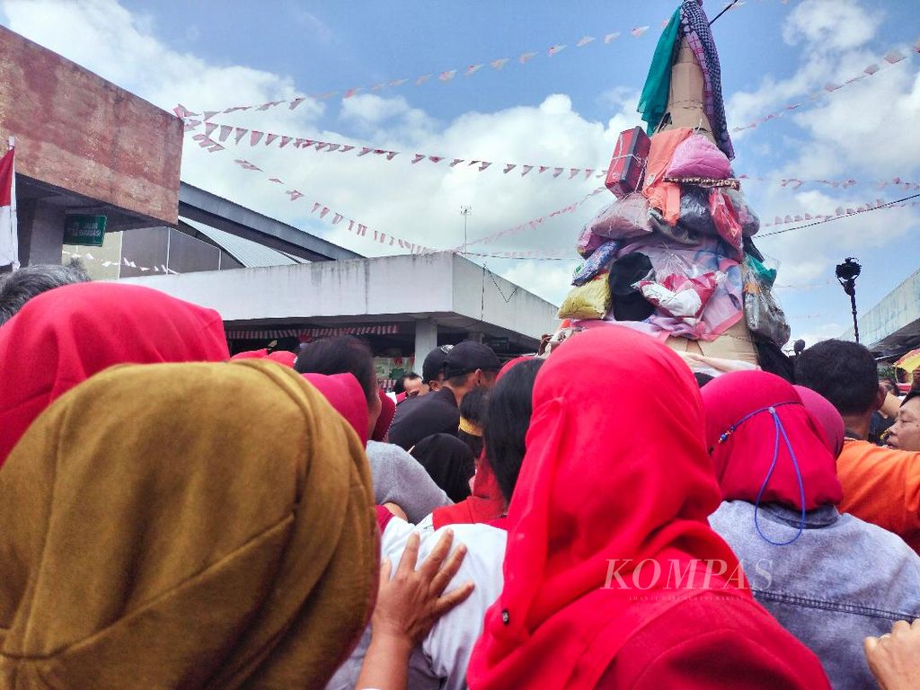 Sejumlah pedagang dan pembeli berebut barang dagangan yang disusun menjadi gunungan dalam acara peringatan HUT Kemerdekaan Ke-77 RI di Pasar Rejowinangun, Kota Magelang, Jawa Tengah, Rabu (17/8/2022).