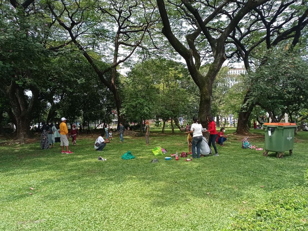 Warga piknik di taman dekat pintu masuk Monumen Nasional, Jakarta yang masih tutup untuk umum karena pandemi Covid-19, Rabu (4/5/2022).