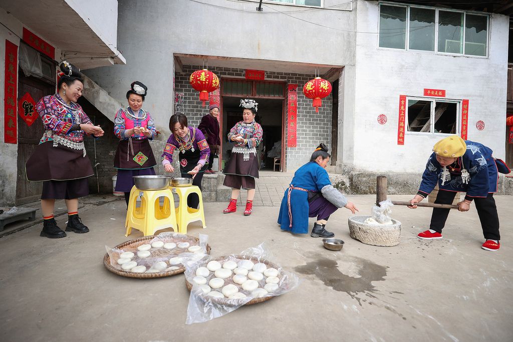 Perempuan-perempuan dari etnis minoritas Miao sedang membuat makanan menjelang Tahun Baru Imlek di daerah Danzhai, Prefektur Otonomi Qiandongnan Miao dan Dong, Provinsi Guizhou, China, Kamis (19/1/2023). 