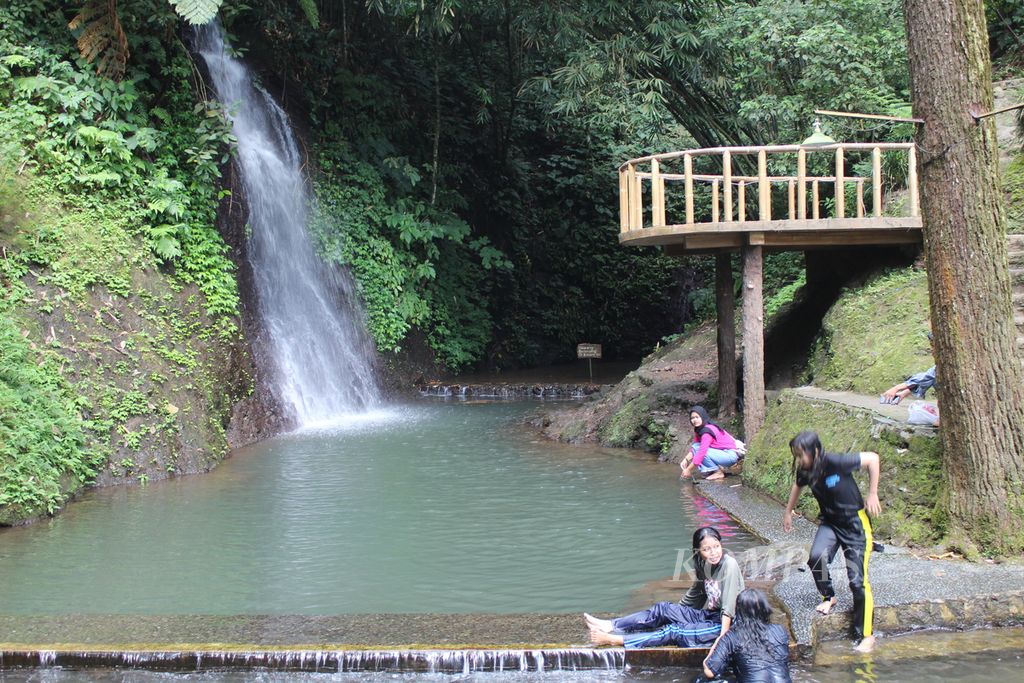 Visitors relax in the Curug Cipeuteuy area in Bantaragung Village, Sindangwangi District, Majalengka Regency, West Java, on Monday (22/4/2024). There, visitors can enjoy the waterfall or curug, swim in the pool, and even camp amidst the pine trees. The community has developed this tourist destination since 2009.