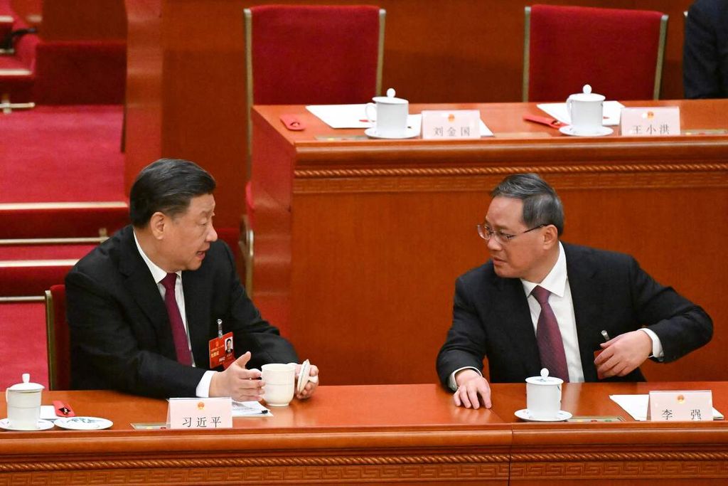 Presiden China Xi Jinping (kiri) berbincang dengan  Anggota Komite Tetap Politbiro Partai Komunis China Li Qiang di sela sesi sidang pleno Kongres Rakyat Nasional China di Aula Besar Rakyat di Beijing, 10 Maret 2023. Li Qiang resmi ditunjuk menjadi perdana menteri China yang baru, menggantikan Li Keqiang.