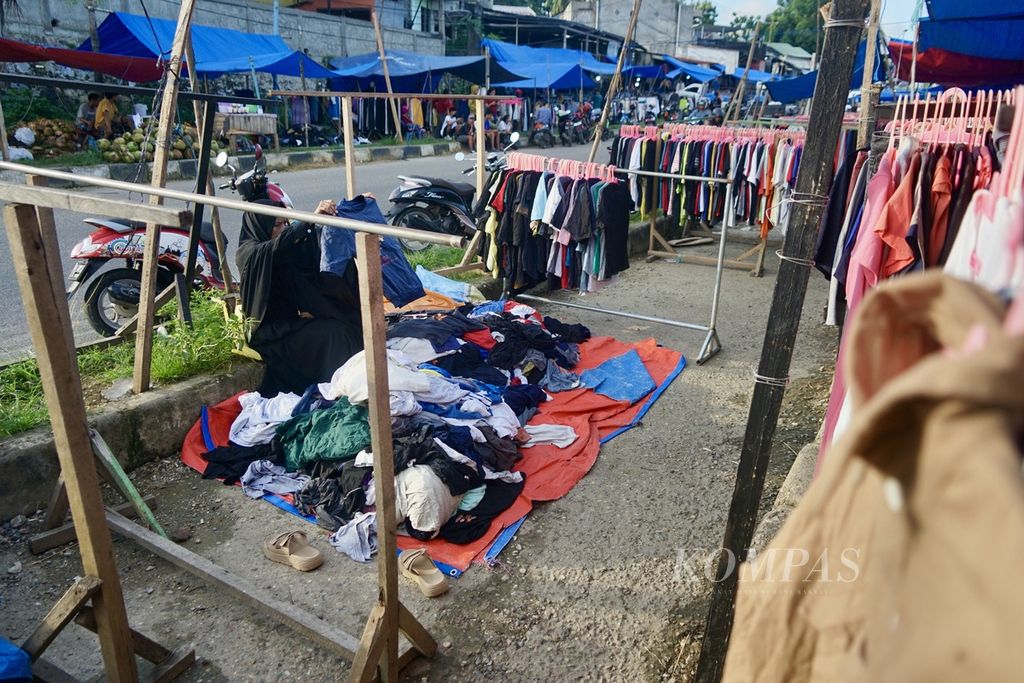 Seorang pedagang pakaian bekas merapikan dagangan akibat minimnya pembeli di Pasar Lawata, Kendari, Sulawesi Tenggara, Sabtu (23/3/2024). 