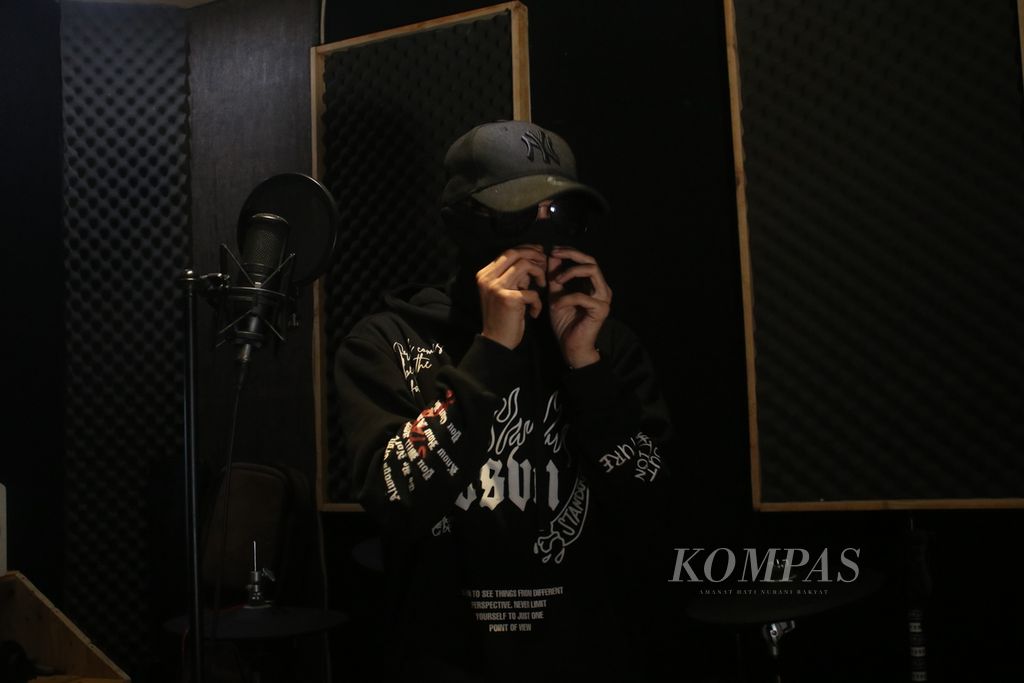 Musisi hiphop asal Majalaya, Bandung, Asep Balon, menggunakan penutup wajah dan kacamata hitam saat berlatih di studio kawasan Desa Cibiru Wetan, Kecamatan Cileunyi, Kabupaten Bandung, Jawa Barat, Rabu (1/3/2023).