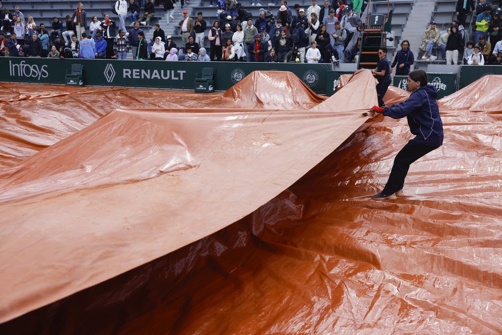 Panitia menutup lapangan pertandingan turnamen Grand Slam Perancis Terbuka di Roland Garros, Paris, Kamis (30/5/2024). Hujan menyebabkan panitia menunda sejumlah pertandingan Perancis Terbuka. 