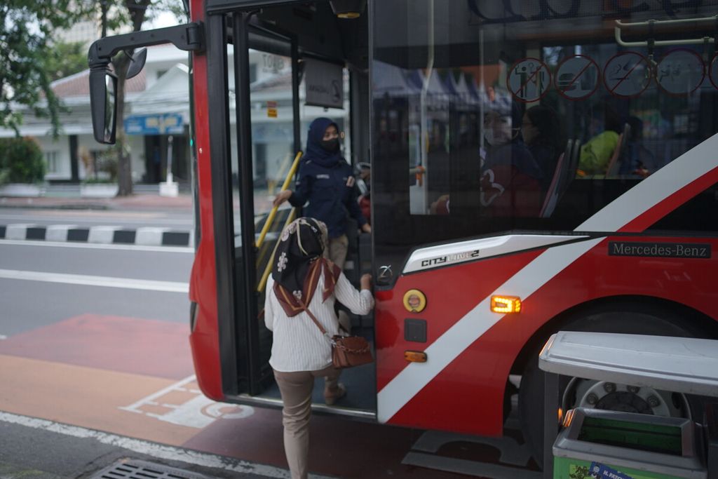 Penumpang menaiki bus Suroboyo Bus dari Halte Panglima Sudirman, Surabaya pada Rabu (2/3/2022) sore. Di awal peluncurannya pada 2018 Suroboyo Bus dikenal sebagai “bus botol” karena calon penumpang dapat membayar dengan botol plastik air mineral. Kini, penumpang juga bisa membayar via uang elektronik.