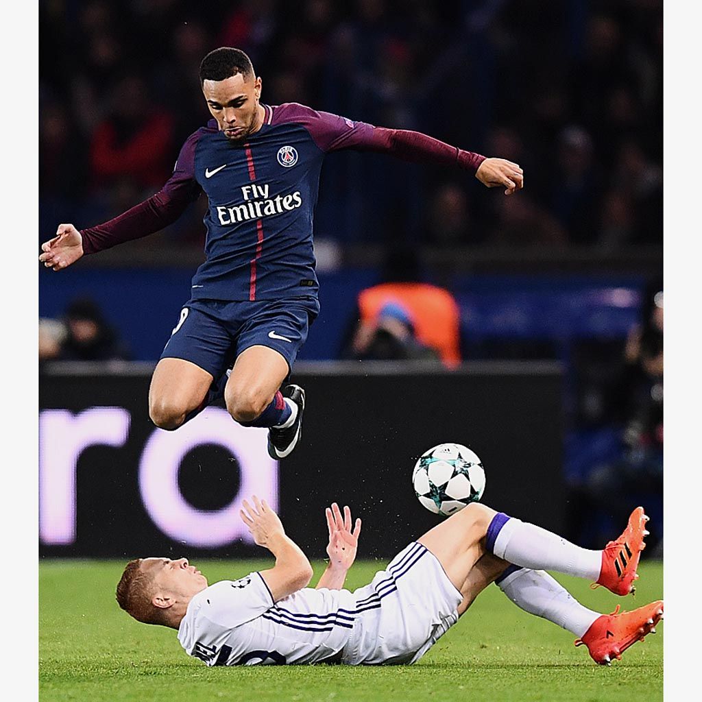 Bek Paris Saint-Germain, Layvin Kurzawa, melompati gelandang Anderlecht, Adrien Trebel, saat perebutan bola pada laga Grup B Liga Champions di Stadion Parc des Princes, Paris, Perancis, Rabu (1/11) dini hari WIB. PSG menang telak 5-0.