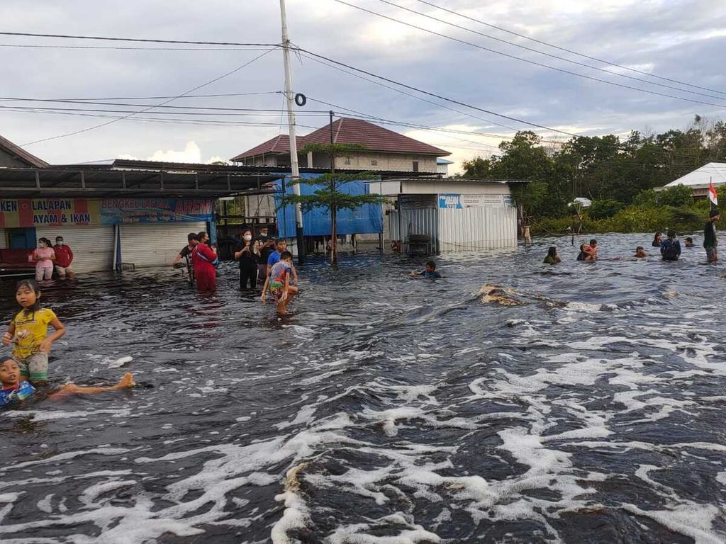 Warga bermain di tengah banjir yang melanda Kasongan, Kabupaten Katingan, Kalimantan Tengah, Rabu (8/9/2021). Warga sudah terbiasa dengan banjir karena setiap tahun selalu dilanda banjir akibat luapan sungai.