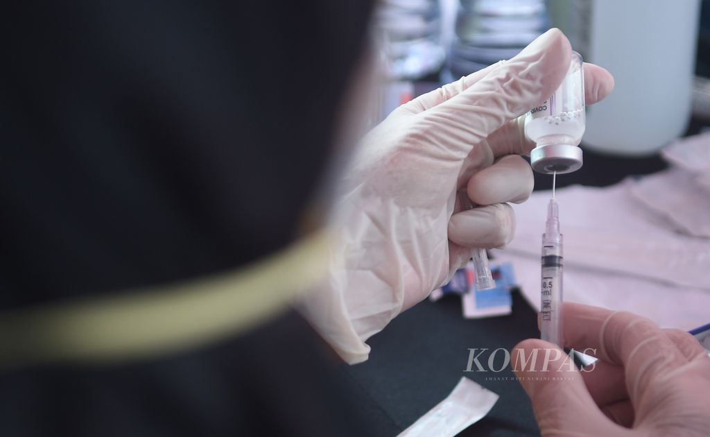 Petugas menyiapkan vaksin Covid-19 saat Kick Off Vaksinasi Booster Jawa Timur di Kantor Dinas Ketenagakerjaan Jatim, Kota Surabaya, Rabu (12/1/2022).