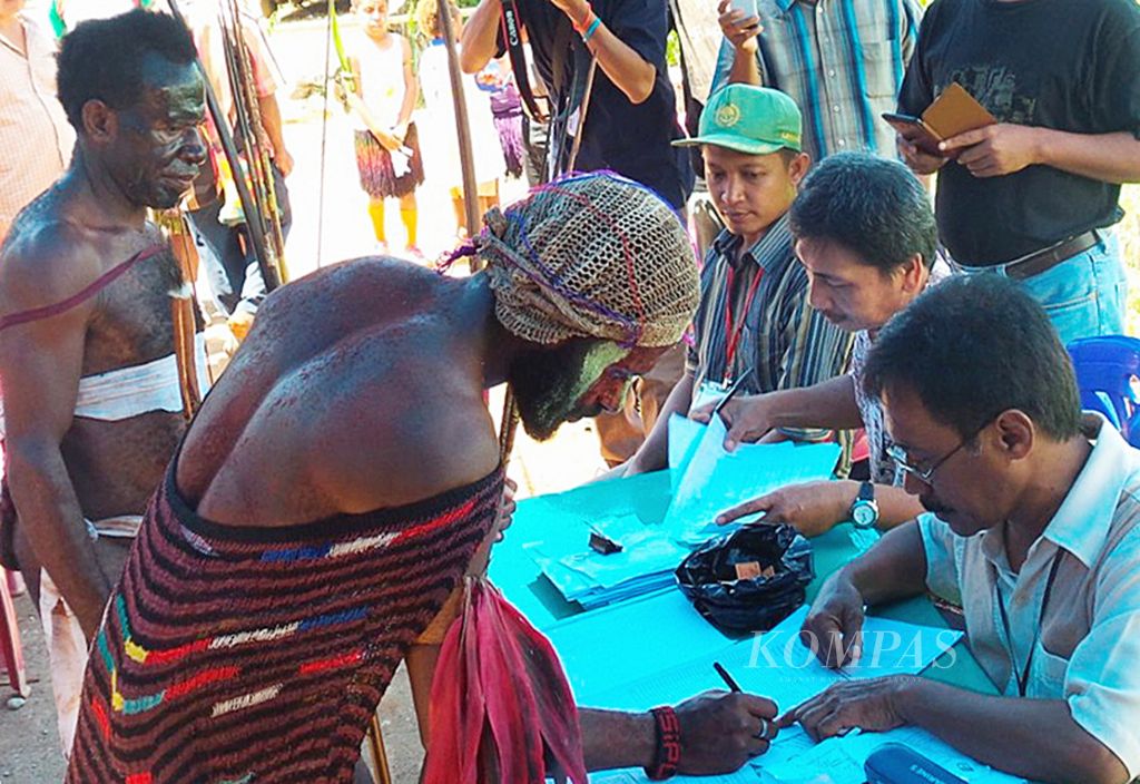 Warga mengenakan pakaian adat asal Wamena, Kabupaten Jaywijaya, Papua, saat mengikuti pemilihan presiden di TPS 21 Kelurahan Imbi, Kota Jayapura, 9 Juli 2014. 