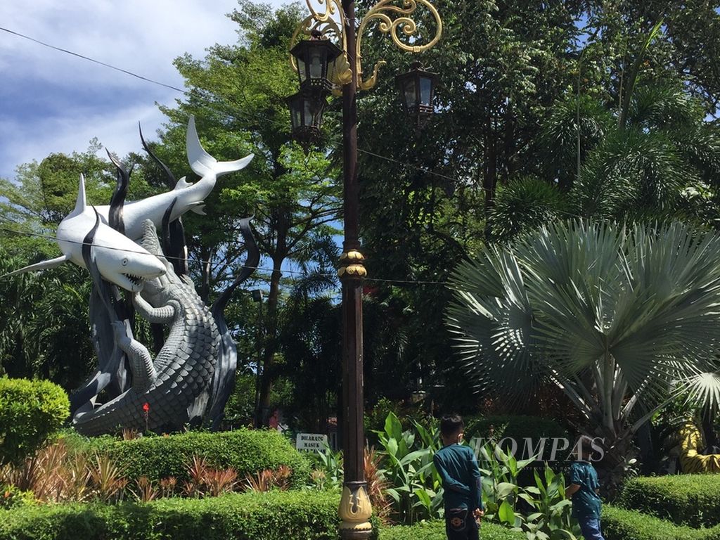 Warga berfoto di Patung Suroboyo di depan gerbang utama Kebun Binatang Surabaya, Jawa Timur, Senin (2/5/2022). KBS masih menjadi salah satu obyek wisata favorit warga yang tidak mudik saat Lebaran. Patung Suroboyo juga menjadi lokasi favorit untuk berfoto sebelum dan sesudah kunjungan ke KBS.