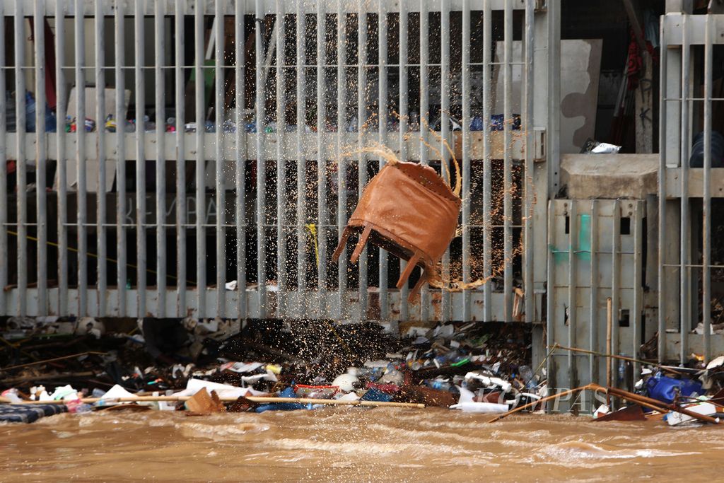 Kursi terbawa arus Sungai Ciliwung di sekitar Pintu Air Manggarai, Jakarta, Kamis (2/1/2020). Berbagai jenis sampah, seperti plastik, ranting pohon, dan sampah rumah tangga, banyak terbawa arus Sungai Ciliwung. 