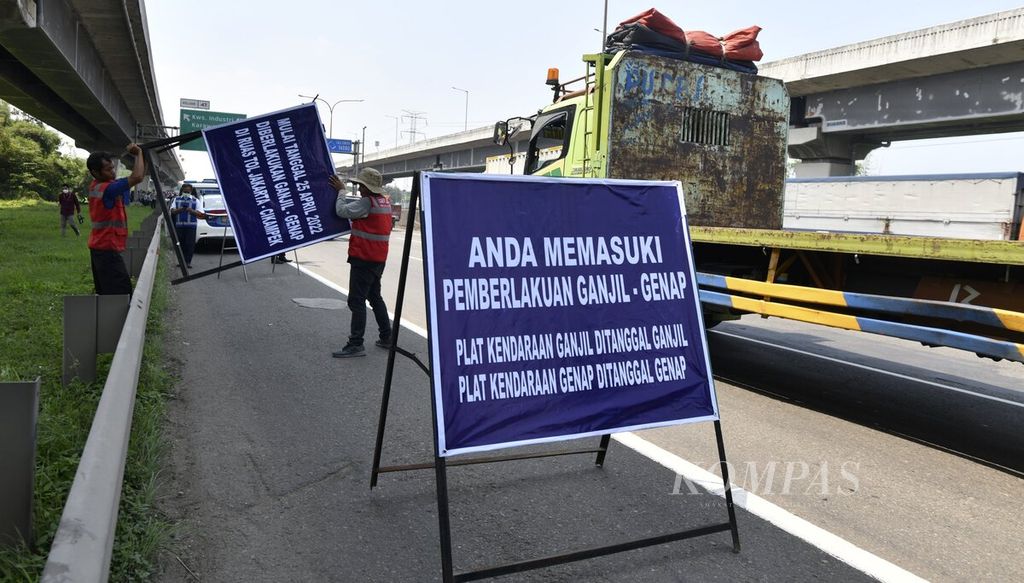 Officers install an information board during a trial for applying odd-even traffic engineering on the Jakarta-Cikampek Toll Road at kilometer 47 Karawang, West Java, Monday (25/4/2022). The trial will be carried out for three days until Wednesday (27/4/2022).