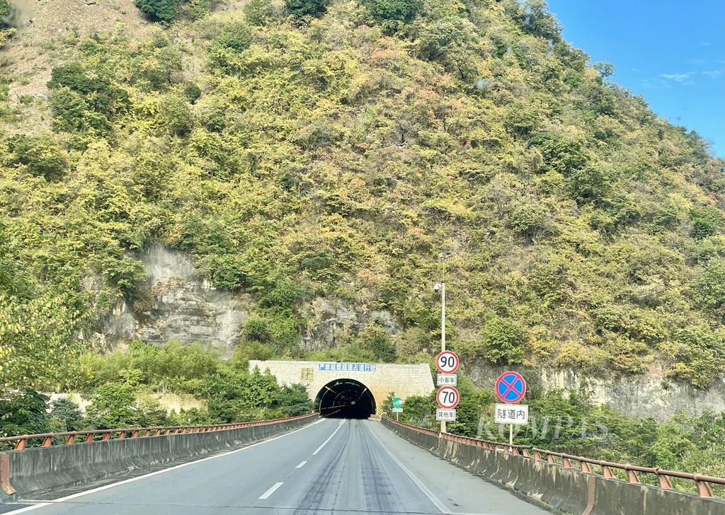 Di sepanjang jalan tol dari ibu kota Yunnan, Kunming, ke Prefektur Wenshan, ada banyak terowongan yang menembus bukit dan gunung karst, Selasa (15/11/2022). Jalan bebas hambatan ini menjadi penghubung antara China dan Vietnam, urat nadi perekonomian yang penting bagi daerah-daerah yang ada di sekitarnya.