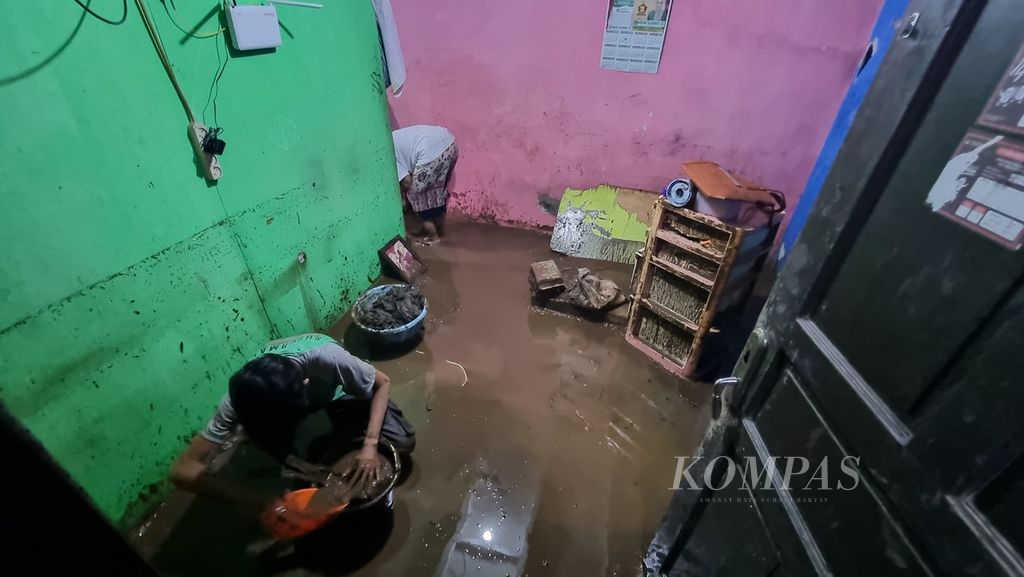 Warga membersihkan rumah dari endapan lumpur saat banjir luapan Sungai Cikapundung yang melintasi daerah tersebut mulai surut di RW 004 Kelurahan Braga, Kecamatan Sumur Bandung, Kota Bandung, Jawa Barat, Kamis (11/1/2024).