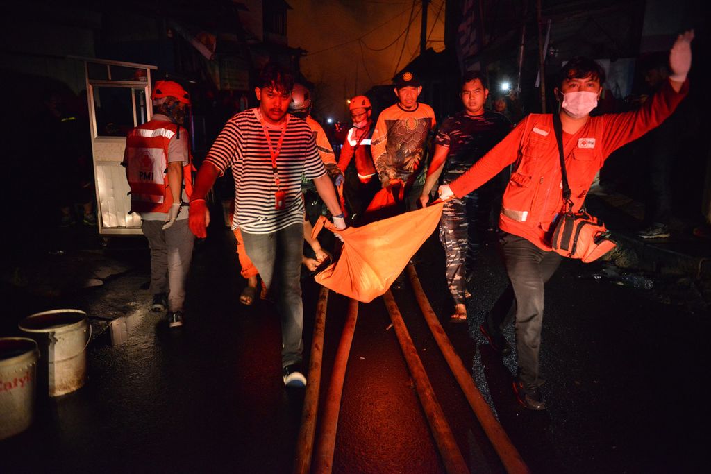 Petugas mengevakuasi korban kebakaran yang terjadi di Jalan Tanah Merah Bawah, Kecamatan Koja, Jakarta Utara, Jumat (3/3/2023). 