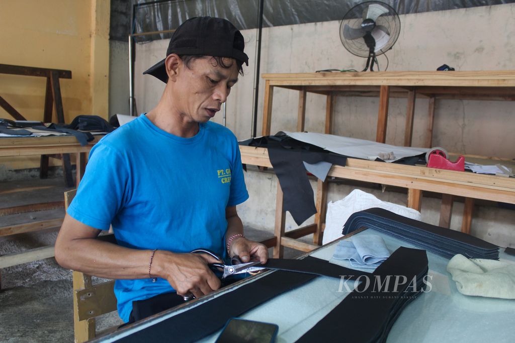 Salah satu pekerja PT Garut Makmur Perkasa di Kabupaten Garut, Jawa Barat, memotong kulit untuk jok pesawat Lion Air Group pada Rabu (27/3/2024). Pemotongan kulit sesuai 28 pola yang ditentukan pihak Lion Air Group.